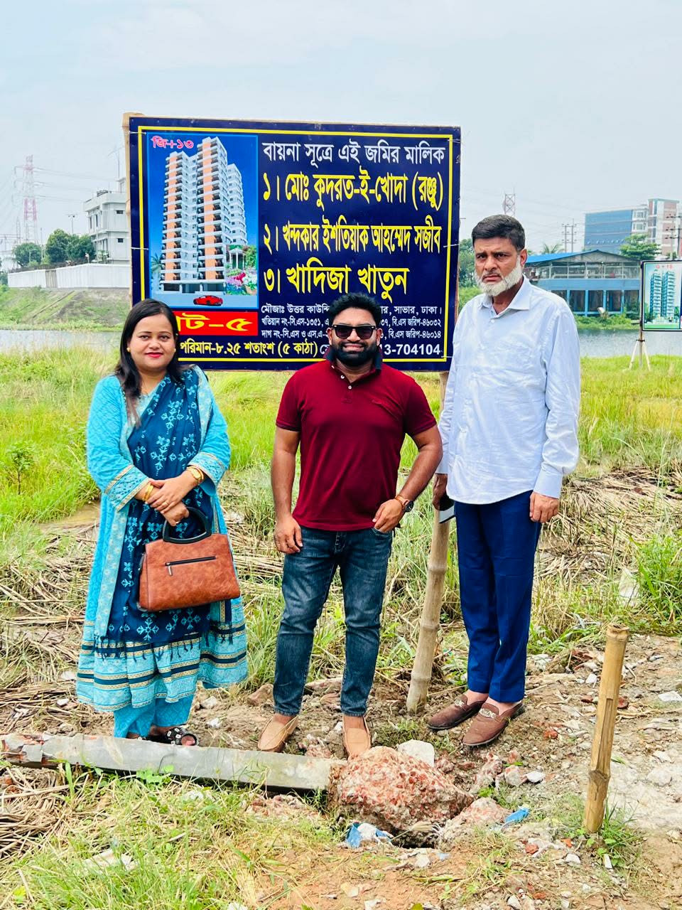 Three people visiting a property site beside a land information sign